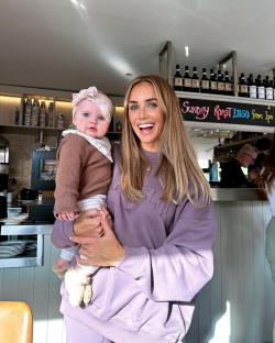 Woman holding baby in a restaurant.
