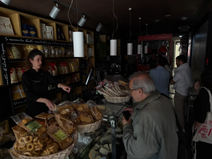 A woman helps a customer at a deli counter.