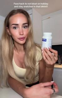 Woman holding a supplement bottle, suggesting a way to avoid bloating.