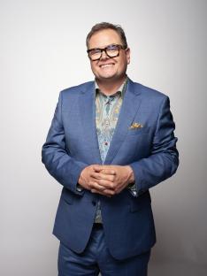 Alan Carr in a blue suit.