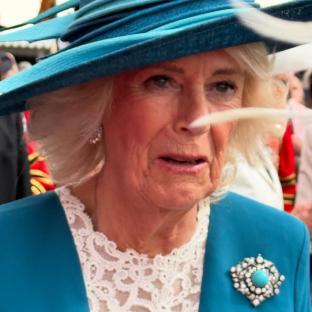 Close-up of Camilla, Queen Consort, wearing a teal suit and hat.