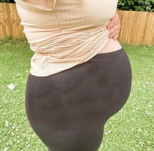 Person's pregnant belly in profile.