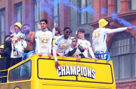 Leeds United players celebrating on a victory parade bus.