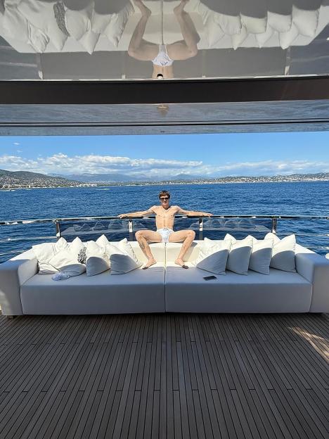 Man in white briefs relaxing on a yacht.