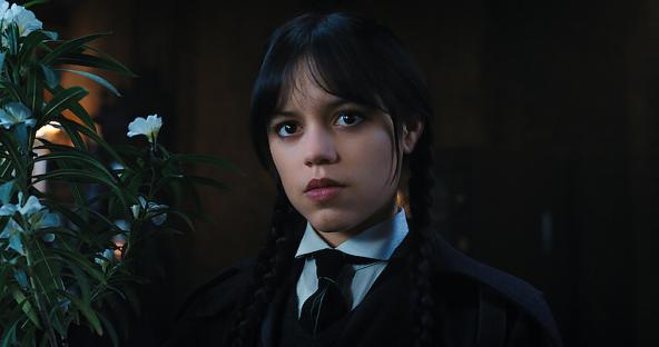 A girl with dark hair in a school uniform looks directly at the camera.