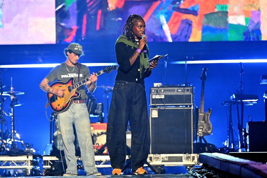 Cat Burns performing onstage with a musician at the Together For Palestine concert.