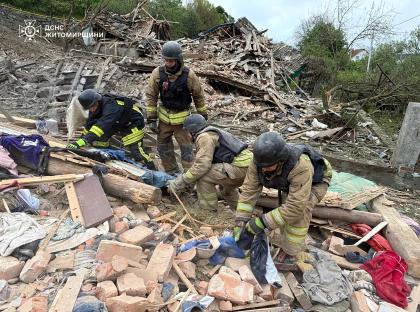 Rescuers searching through rubble at a destroyed house.