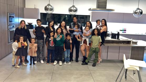 A large family group photo in a modern kitchen.