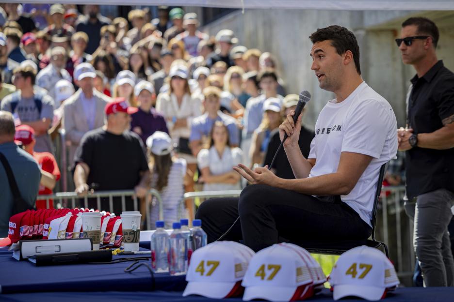 Charlie Kirk speaking at an outdoor event.
