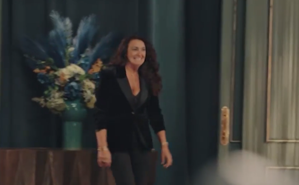 Woman in a black blazer smiling.
