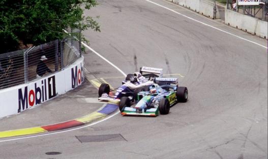 two racing cars on a track with a mobil sign in the background