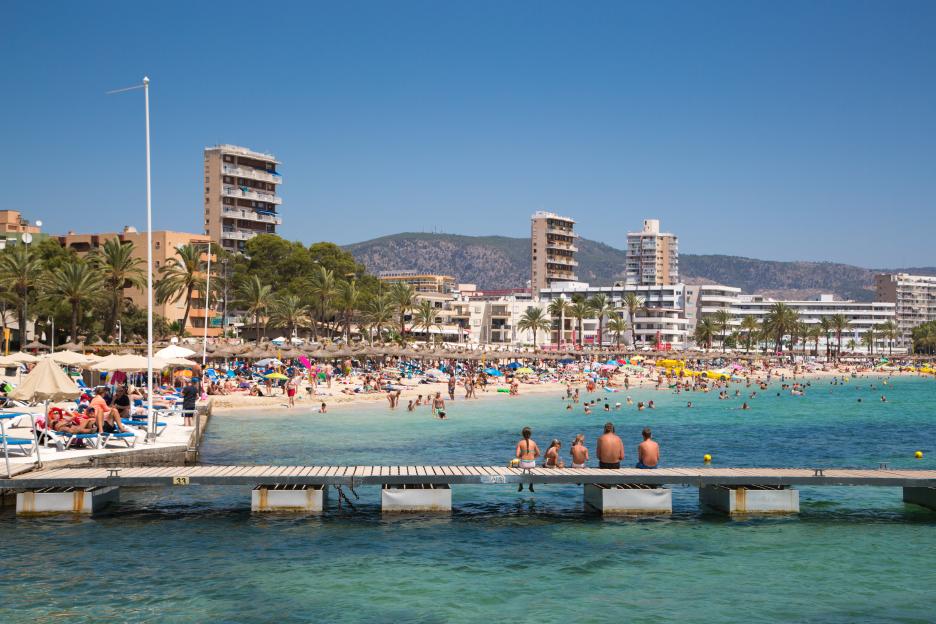 Family relaxes on pier at Playa de Magaluf beach