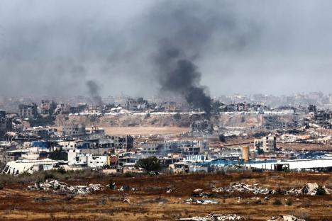 Smoke billows over destroyed buildings in Gaza.