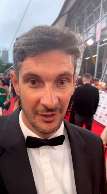 Man in tuxedo on red carpet.