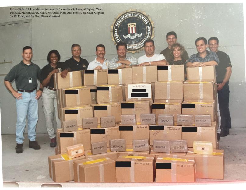 FBI agents pose with boxes of seized items.