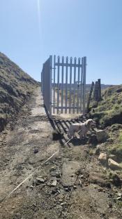 Metal fence gate erected on a disused quarry road.