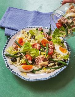 Tuna pasta salad with hard-boiled eggs, green beans, and olives.
