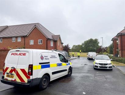 Police cars and van at a crime scene.