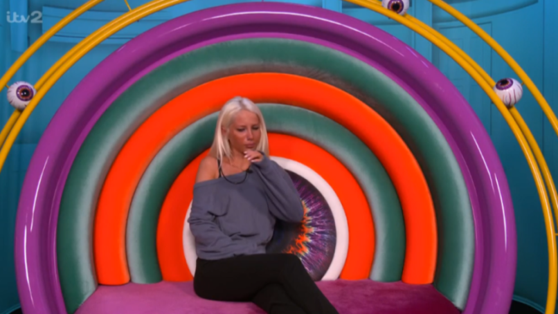A woman sitting in a colorful rainbow chair.