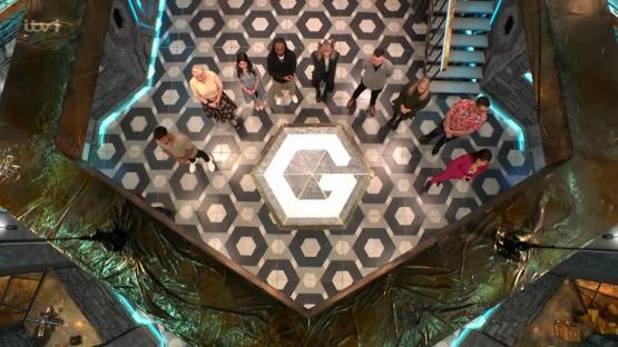 Overhead view of contestants on a game show set.