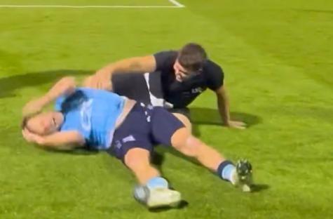 Screenshot of two soccer players on the field, one on the ground and the other kneeling over them.