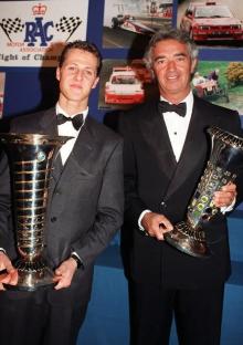Michael Schumacher and Flavio Briatore holding their Formula 1 World Championship awards.
