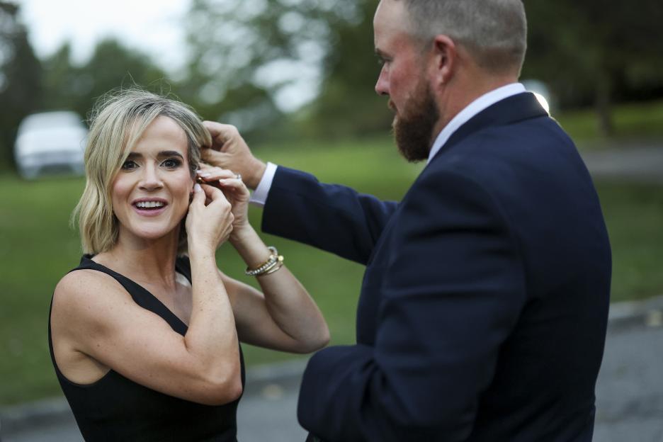 Shane Lowry helps his wife Wendy Lowry with her earring before a group photo.