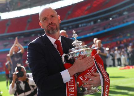 Erik ten Hag holding the FA Cup trophy.