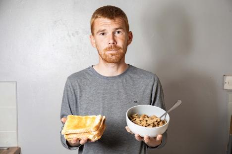 Man holding toast and cereal, illustrating his limited diet due to ARFID.
