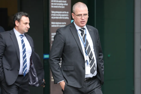 Two men in suits walking outside a building.