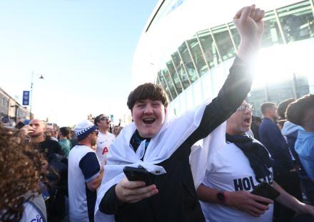 A Tottenham Hotspur fan celebrates outside the stadium.