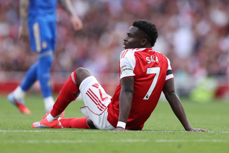 Bukayo Saka of Arsenal receiving treatment for an injury on the field.