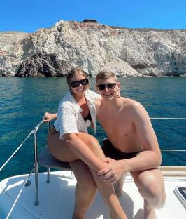 Couple on a boat near a cliff.