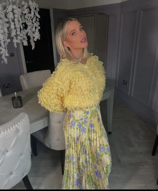 Woman in yellow cardigan and floral midi skirt.