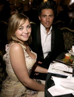 a man and a woman sit at a table with plates of food