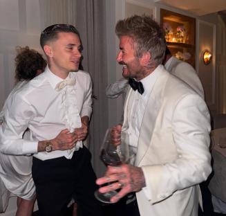 Romeo and David Beckham laughing together at an event.