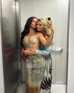 Two women taking a selfie in an elevator.