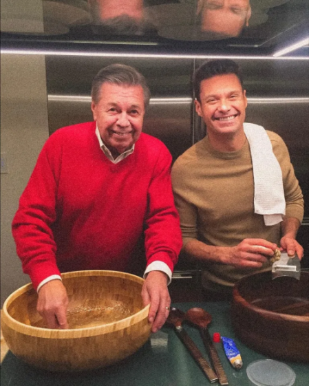 Ryan Seacrest and his father preparing food in a kitchen.