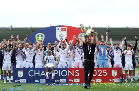 Leeds United manager Daniel Farke celebrates with the team and trophy.