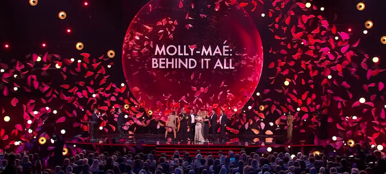 Molly-Mae: Behind It All awards show stage with performers and audience.