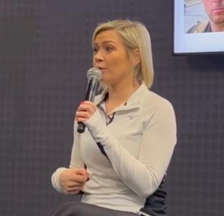 Woman speaking into microphone.