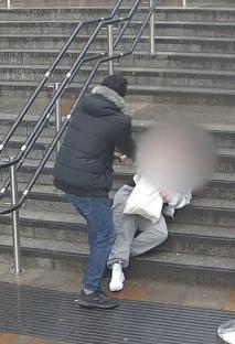 Person assisting a person who has fallen on stairs.