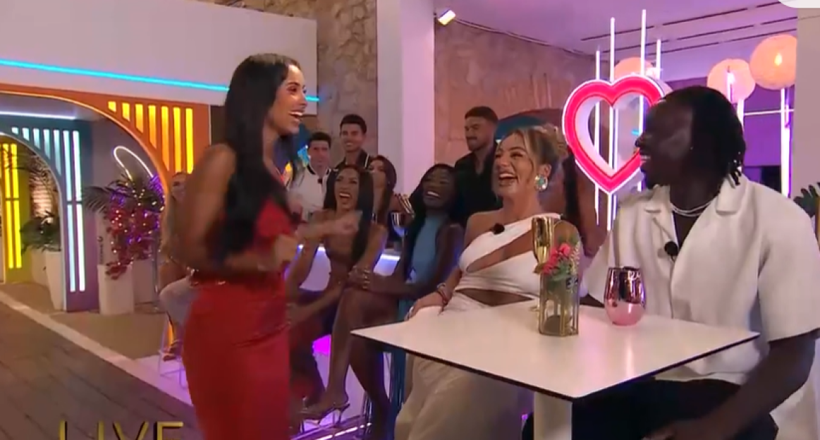 Screenshot of a group of people laughing and talking on a reality TV show.