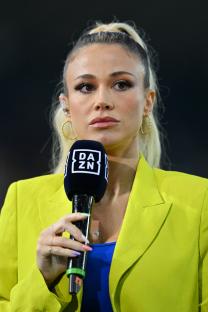 a woman in a yellow jacket holds a da zn microphone