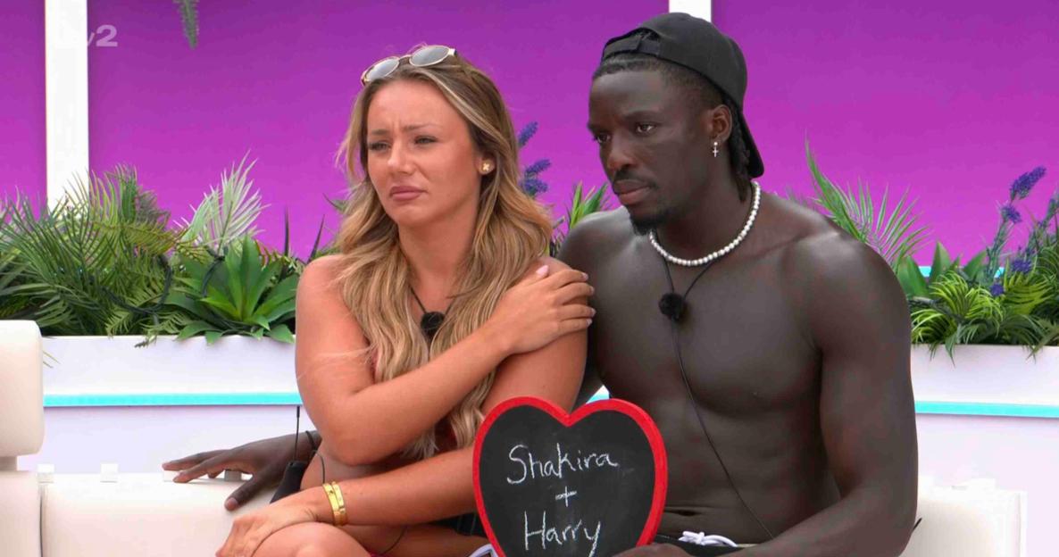 Shakira and Harry from Love Island holding a heart-shaped sign.