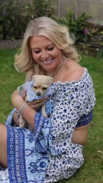 Woman holding a small dog.