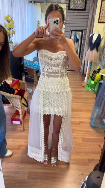 Woman in a white crocheted dress with an overlay.