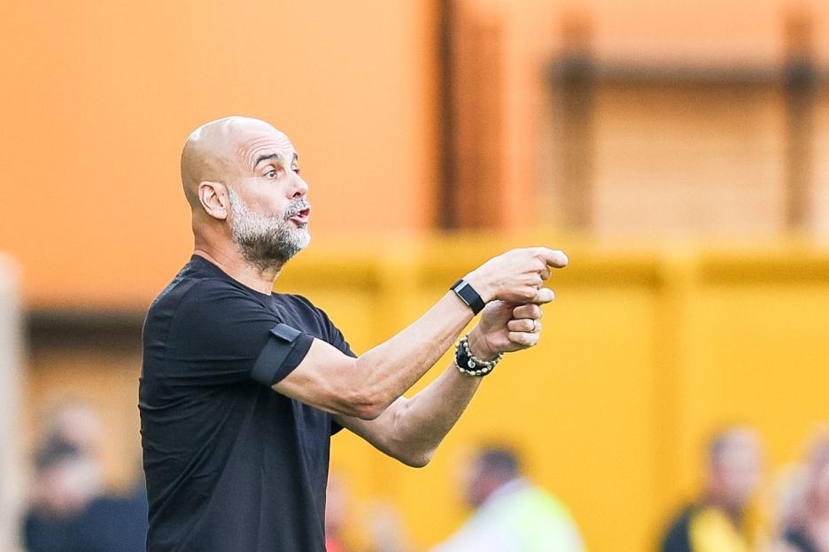 Pep Guardiola giving instructions during a soccer match.