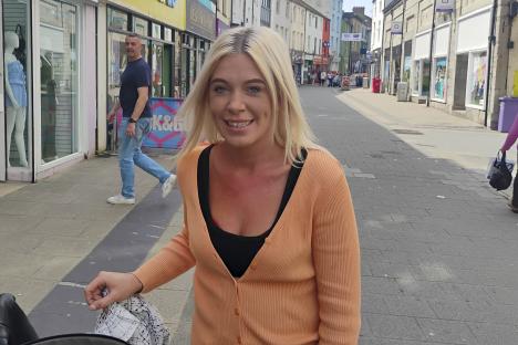 Woman with blonde hair and peach cardigan in Bangor, Wales, with her young daughter.