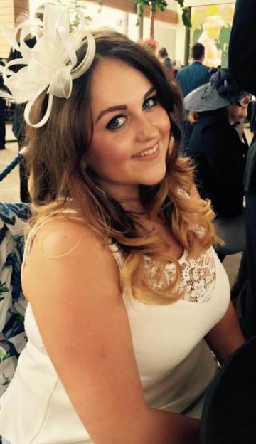 Charlotte Brown, a young woman with long brown hair, wearing a white dress and a white fascinator.
